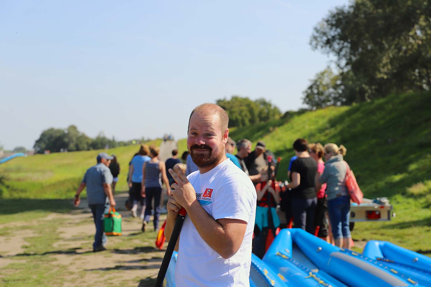 Einweisung für Schlauchboottour – Vorbereitung auf das Abenteuer Mann gibt einer Gruppe eine Einweisung für Schlauchboote und hält ein Paddel